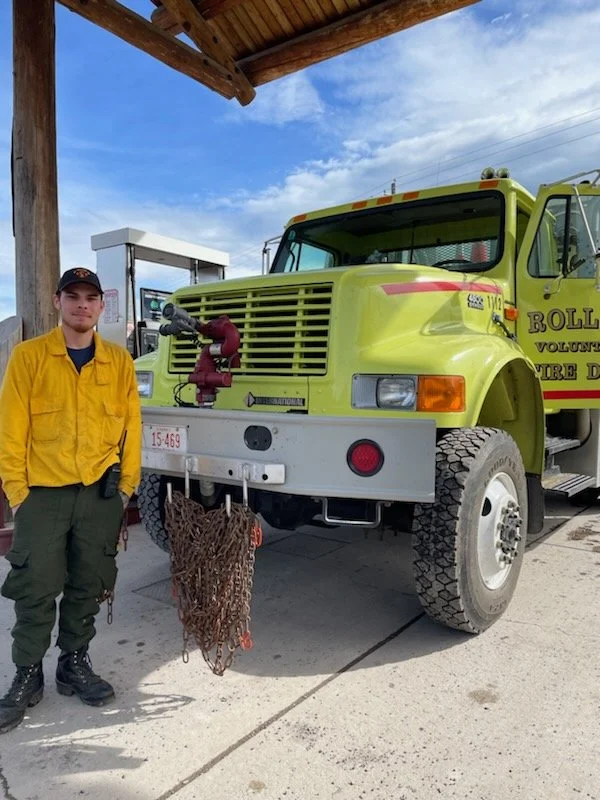 A volunteer beside a Rollins wildland engine