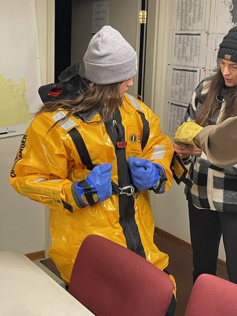 A volunteer suiting up in a water rescue suit