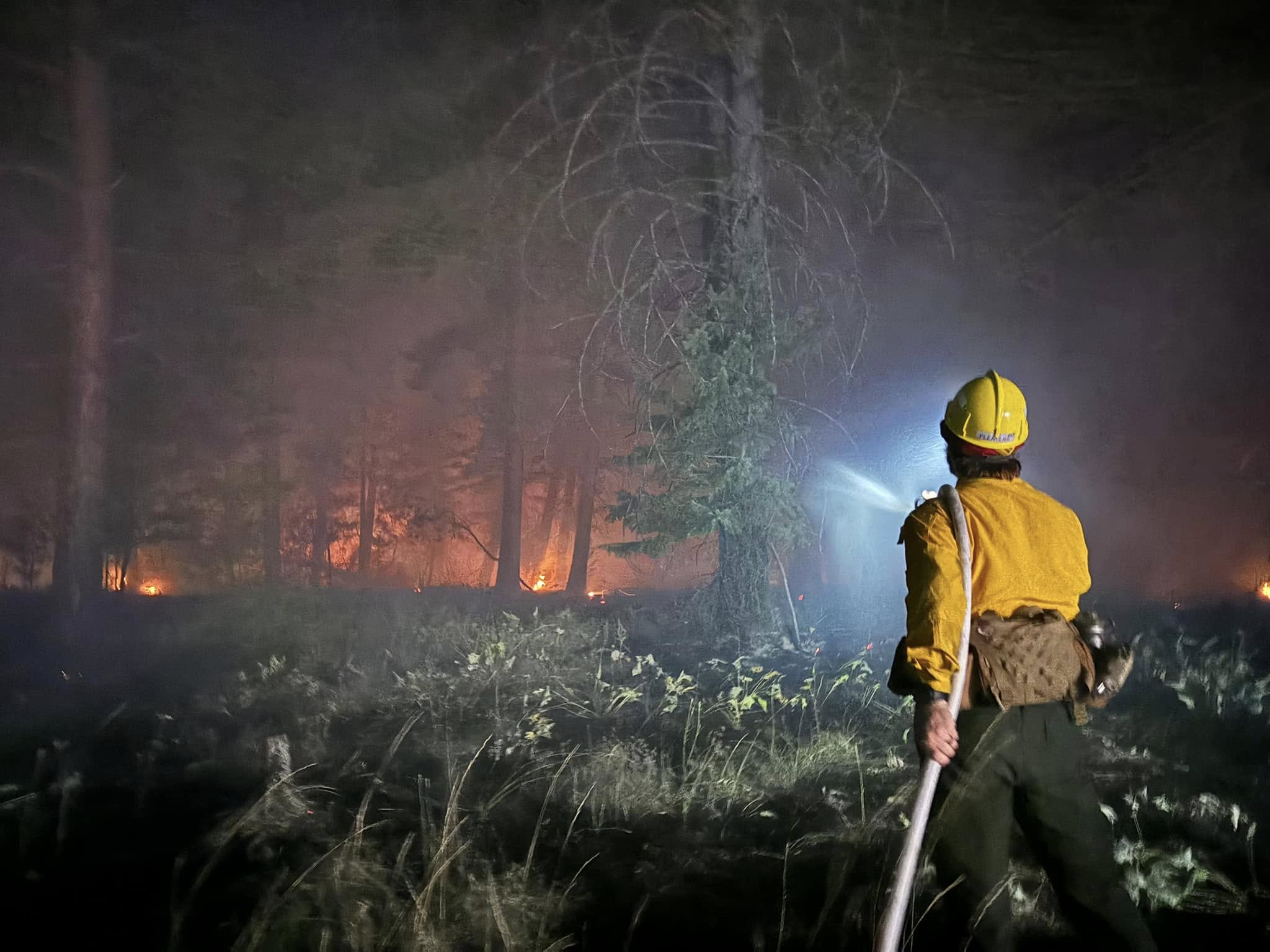 A Rollins firefighter working a fire after dark