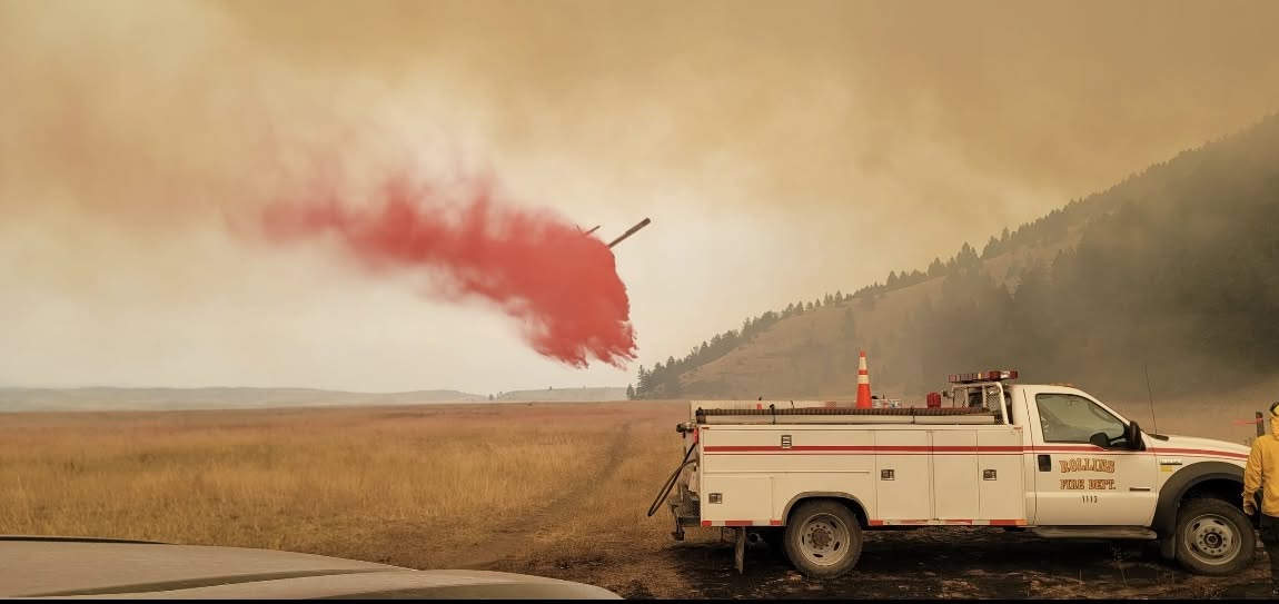 An air tanker drops retardant near a Rollins brush truck