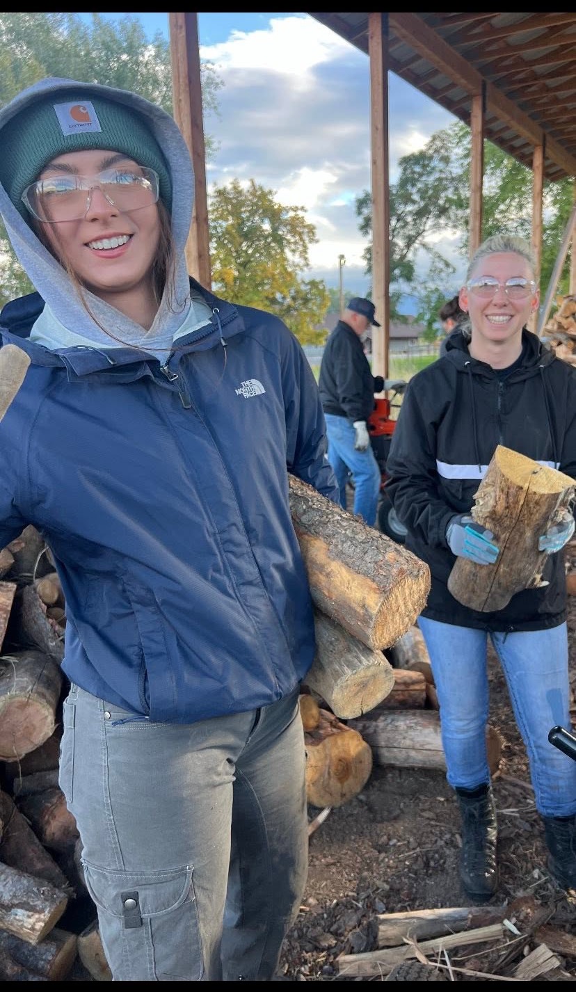 Volunteers stacking firewood at a department work day